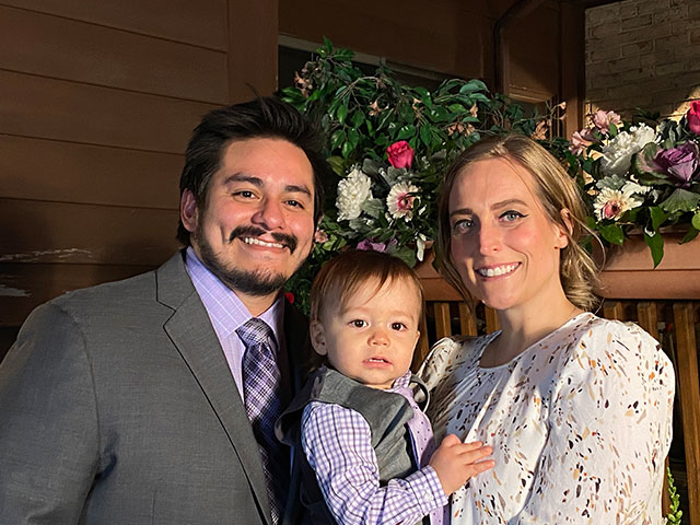 Dressed up family picture of Alex, wife and son.