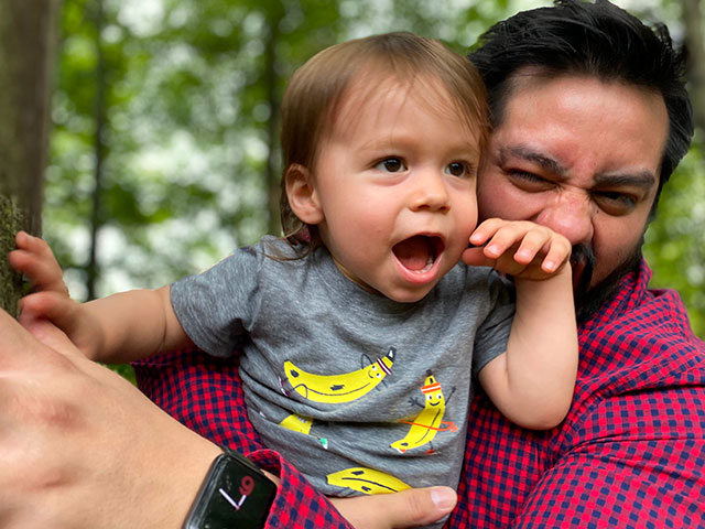 Alex holding and playing with his son