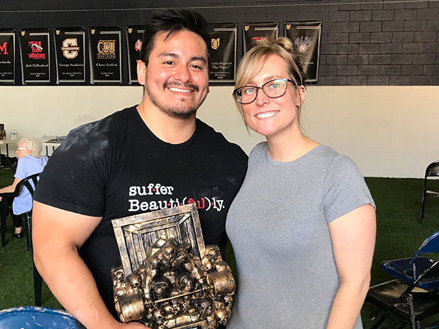 Alex and wife pose with powerlifting award