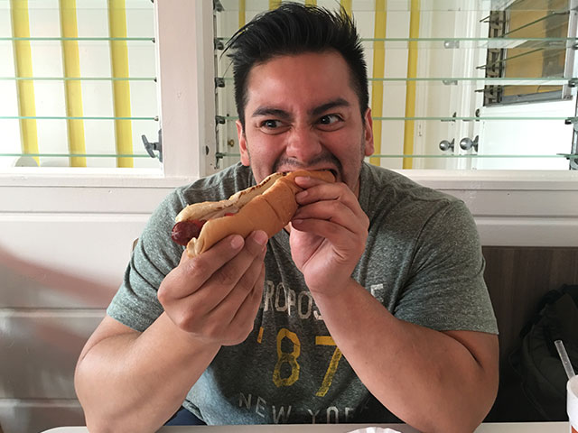 Alex aggressively enjoying a grill hotdog