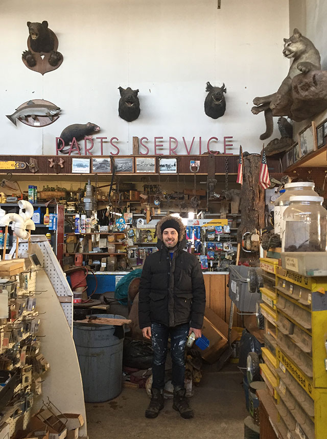 Donny wearing a warm coat in interesting hardware store.