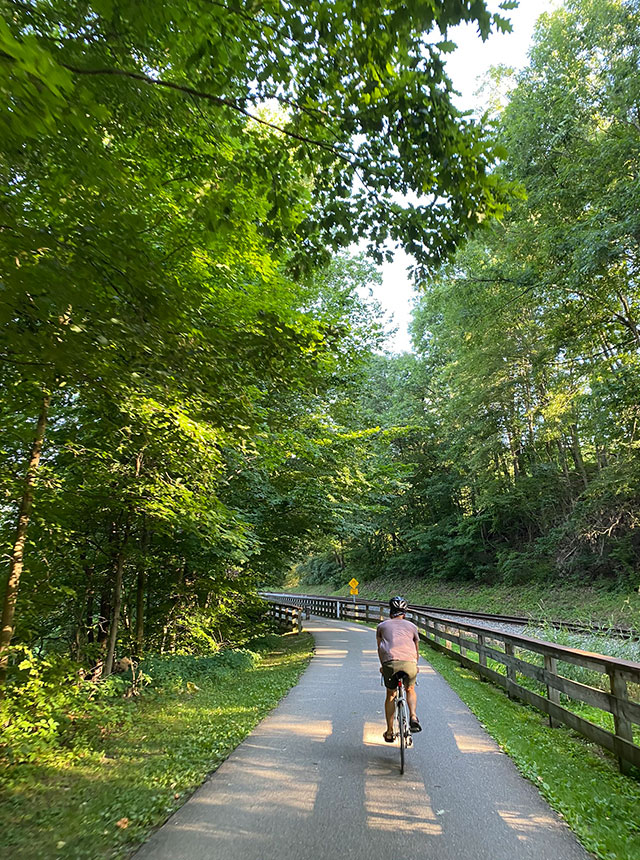 Donny biking on a trail on a beautiful day.