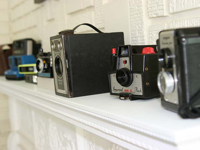 old cameras on fireplace mantle