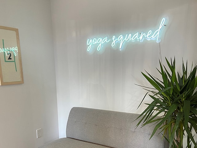 Yoga Squared neon sign in an office.