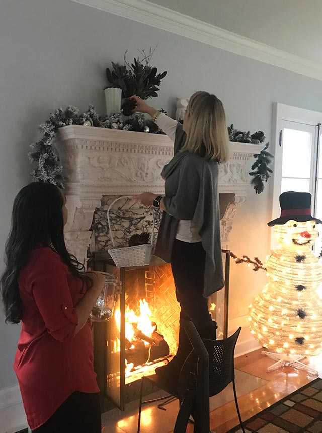 Jenn and Katie decorating fireplace mantel