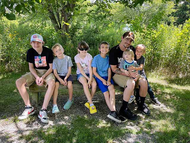 Family photo sitting on bench in park