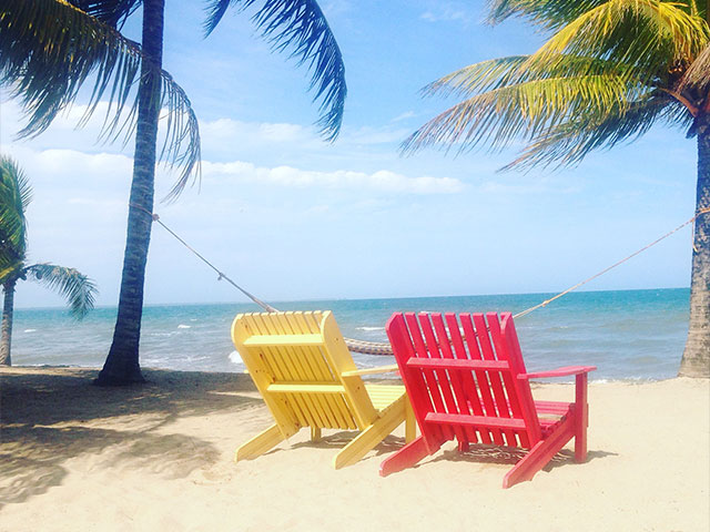 Chairs on Belize beach overlooking ocean