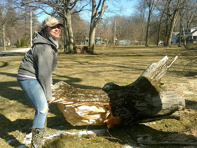 Sierra doing yard work lifting cut tree